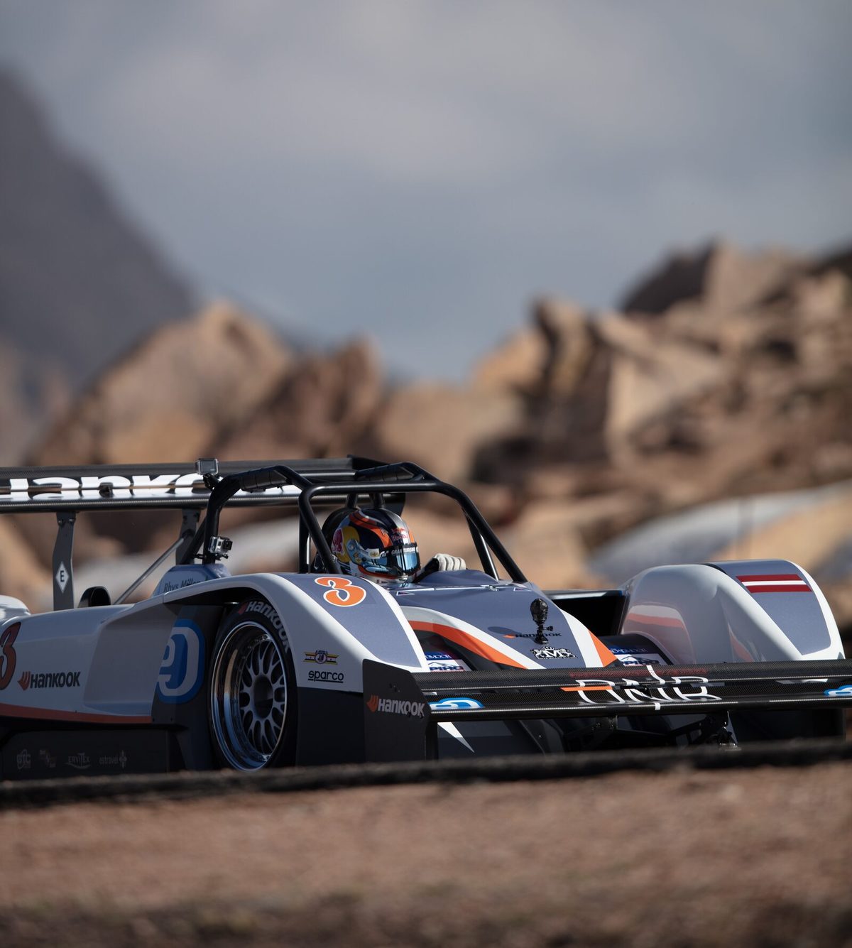 A panned motorsport keeper: streaked background, crisp car, read as Sharp